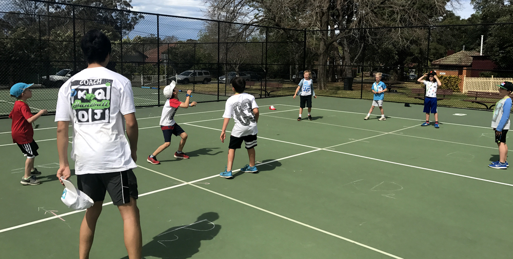 Kids having fun playing handball at a holiday camp program