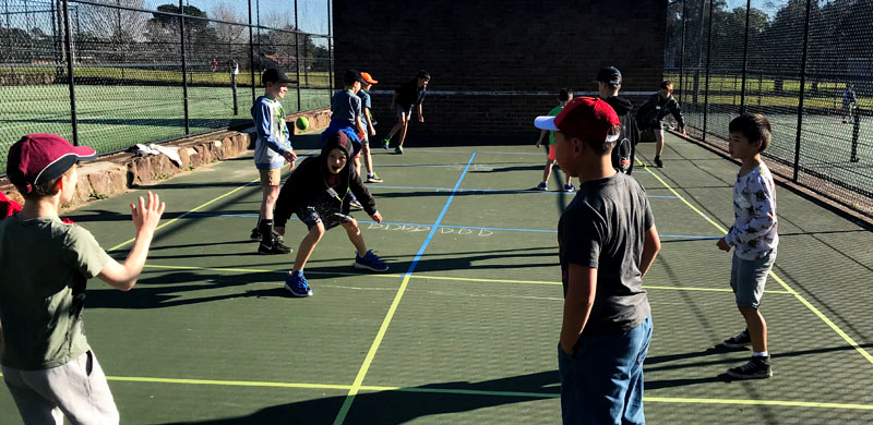Kids having fun playing handball at a private lesson program