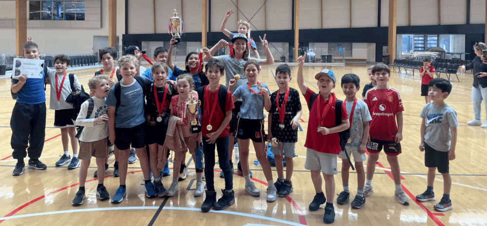 Kids having fun playing handball at a holiday camp program