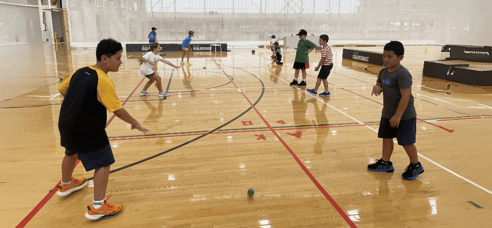 Kids having fun playing handball at a holiday camp program