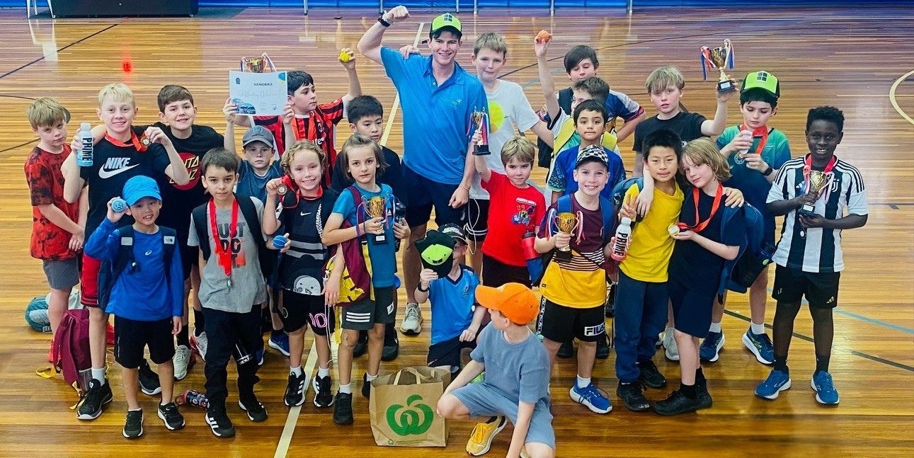 Kids having fun playing handball at a holiday camp program