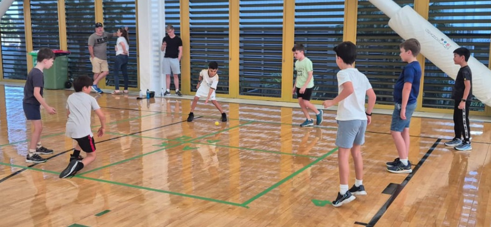 Kids having fun playing handball at a holiday camp program