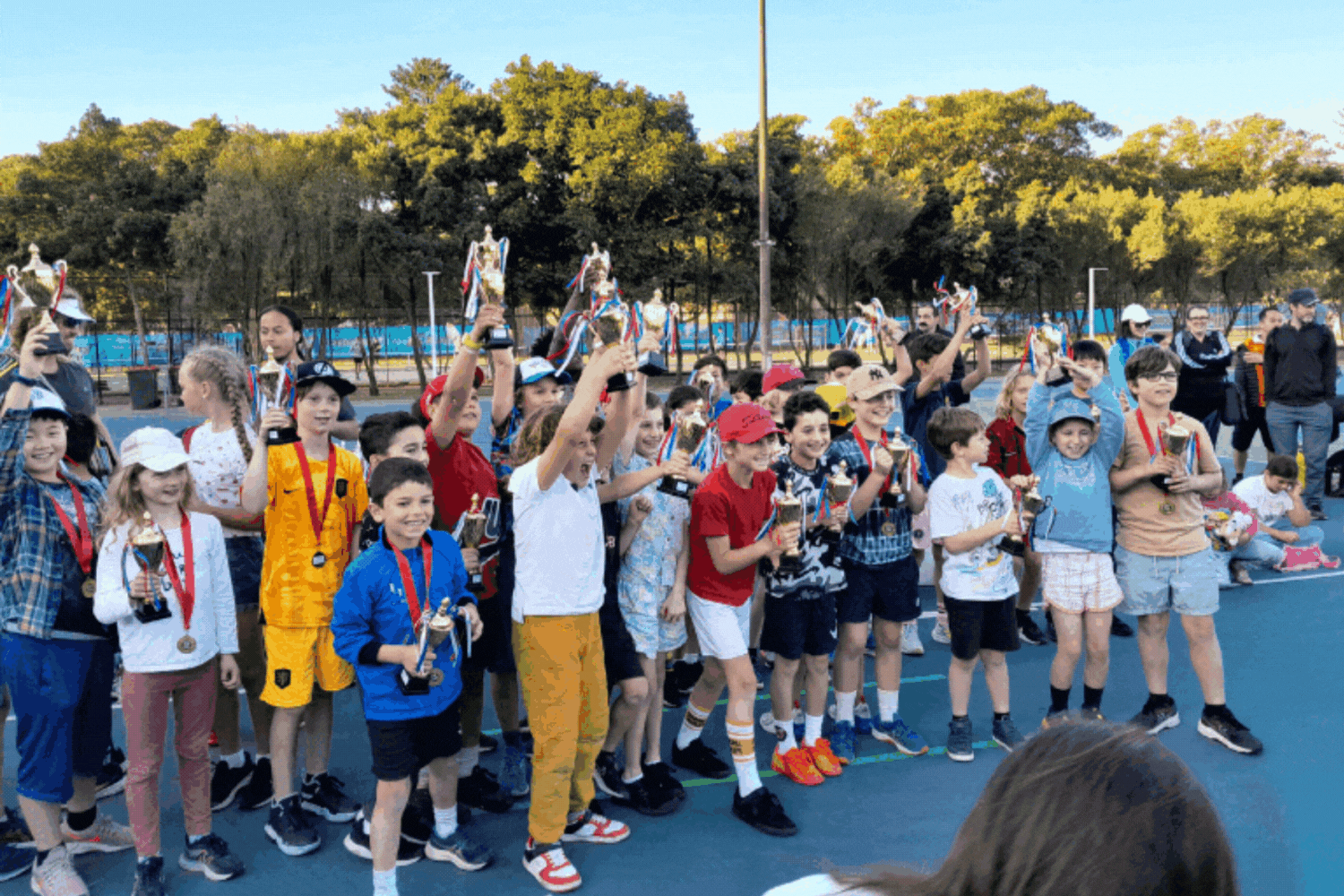 Kids celebrating while holding a trophy