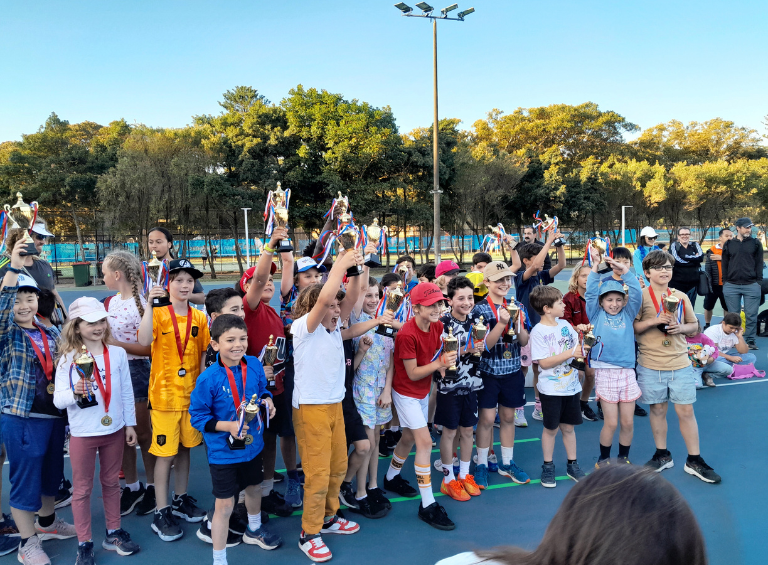 Kids celebrating while holding a trophy